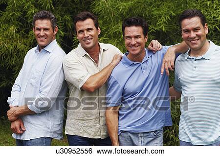 Portrait of a mid adult man with three mature men posing and smiling View Large Photo Image Stock Photograph - Portrait of a mid adult man with three mature men posing and smiling. Fotosearch
