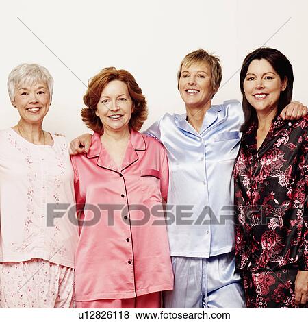 Stock Photo - Portrait of three mature women and a senior woman standing together and smiling. Fotosearch