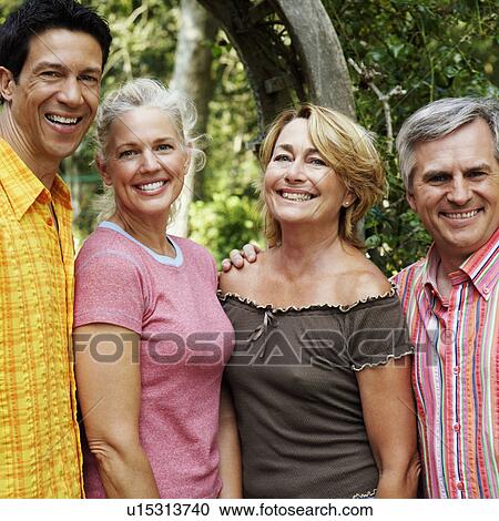 Stock Image - Portrait of two mature couples smiling. Fotosearch