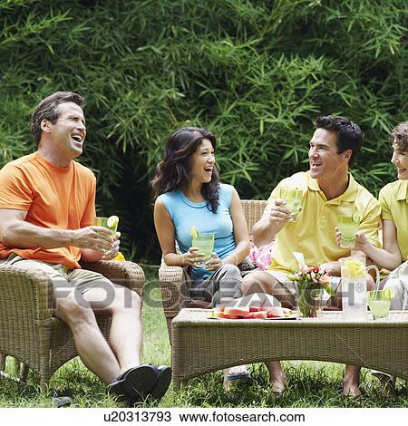 Stock Image - Three mature men and two mature women sitting together. Fotosearch
