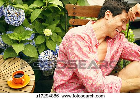 Stock Photograph - Close-up of a mature man sitting on a chair and smiling. Fotosearch