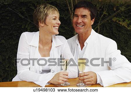 Mature couple holding cups in the kitchen and smiling View Large Photo Image Stock Image - Mature couple holding cups in the kitchen and smiling. Fotosearch