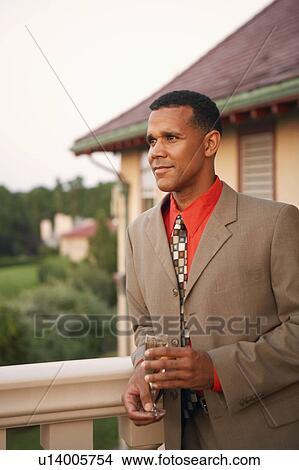 Mature man holding a glass of champagne View Large Photo Image Picture - Mature man holding a glass of champagne. Fotosearch