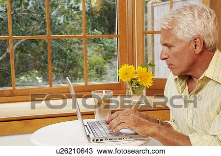 Stock Image - Mature man using a laptop. Fotosearch