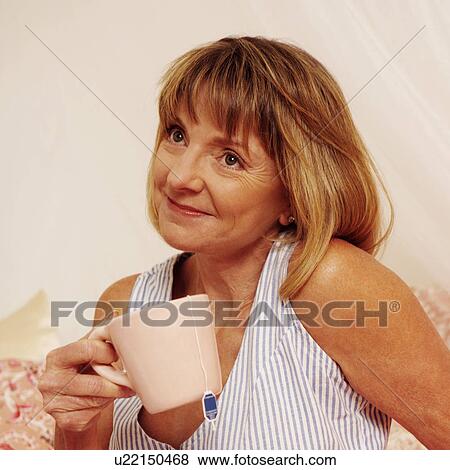 Mature woman holding a cup of tea View Large Photo Image Stock Photo - Mature woman holding a cup of tea. Fotosearch