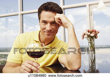Portrait of a mature man holding a glass of wine View Large Photo Image Stock Image - Portrait of a mature man holding a glass of wine. Fotosearch