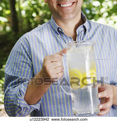 Portrait of a mature man holding a pitcher of lemonade View Large Photo Image Stock Image - Portrait of a mature man holding a pitcher of lemonade. Fotosearch