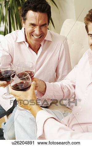 Stock Image - Three people toasting glasses of wine. Fotosearch
