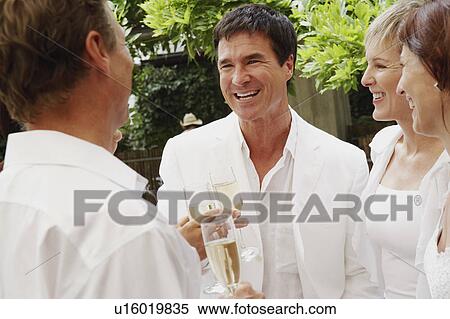 Stock Photography - Two mature couples celebrating with champagne. Fotosearch