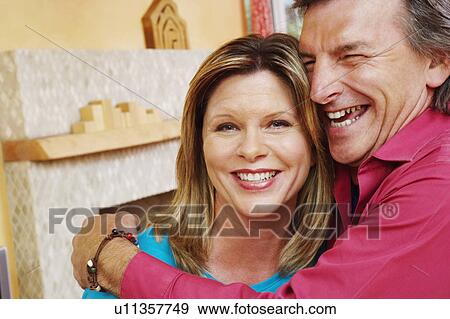 Stock Photo - Close-up of a mature man embracing a mature woman and smiling. Fotosearch