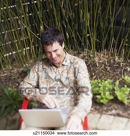High angle view of a mature man using a laptop View Large Photo Image Picture - High angle view of a mature man using a laptop. Fotosearch