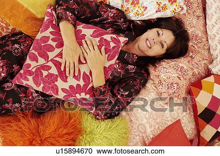 High angle view of a mature woman lying in bed and smiling View Large Photo Image Stock Image - High angle view of a mature woman lying in bed and smiling. Fotosearch