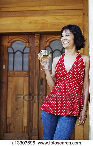 Stock Photography - Mature woman holding a glass of white wine. Fotosearch