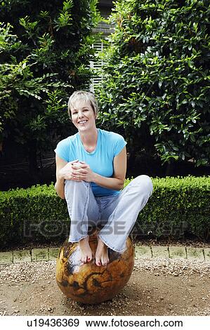 Mature woman sitting on a tree View Large Photo Image Stock Photo - Mature woman sitting on a tree. Fotosearch