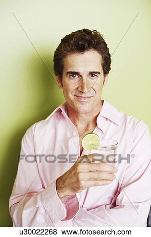 Stock Photo - Portrait of a mature man holding a glass. Fotosearch
