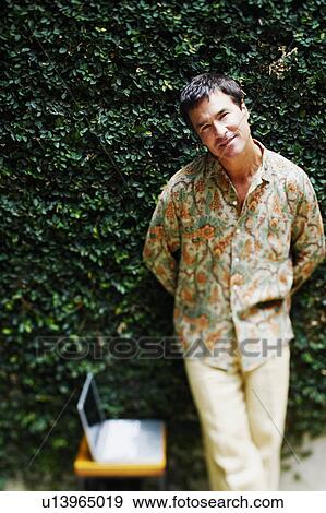 Stock Photo - Portrait of a mature man leaning against a wall. Fotosearch