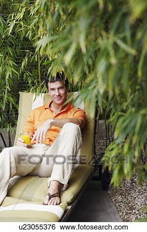 Stock Photograph - Portrait of a mature man reclining on a lounge chair. Fotosearch