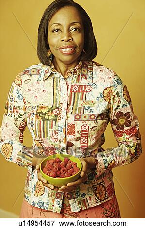 Portrait of a mature woman holding a bowl of raspberries View Large Photo Image Stock Photo - Portrait of a mature woman holding a bowl of raspberries. Fotosearch