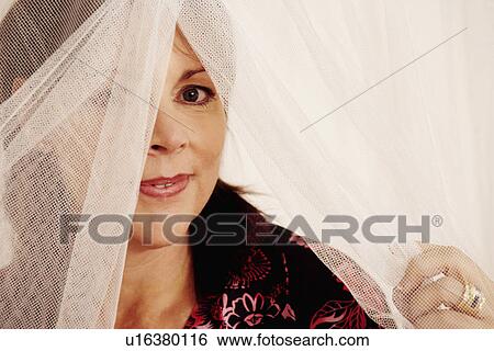 Portrait of a mature woman holding a mosquito net View Large Photo Image Stock Photograph - Portrait of a mature woman holding a mosquito net. Fotosearch