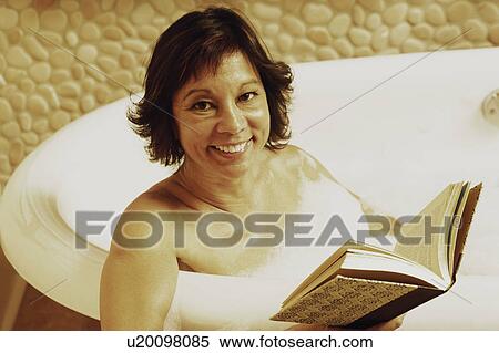 Portrait of a mature woman sitting in a bathtub and holding a book View Large Photo Image Stock Photography - Portrait of a mature woman sitting in a bathtub and holding a book. Fotosearch