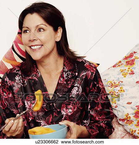 Close-up of a mature woman eating papaya with a fork View Large Photo Image Stock Image - Close-up of a mature woman eating papaya with a fork. Fotosearch