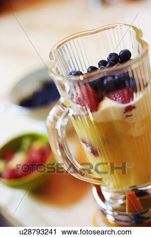 Stock Image - Mango shake in an electric mixer. Fotosearch