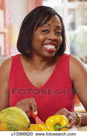 Portrait of a mature woman cutting vegetables and smiling View Large Photo Image Stock Image - Portrait of a mature woman cutting vegetables and smiling. Fotosearch