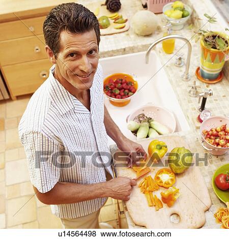Portrait of a mature woman cutting yellow bell peppers in the kitchen View Large Photo Image Stock Photo - Portrait of a mature woman cutting yellow bell peppers in the kitchen. Fotosearch