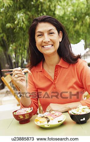 Portrait of a mature woman eating with chopsticks View Large Photo Image Stock Image - Portrait of a mature woman eating with chopsticks. Fotosearch