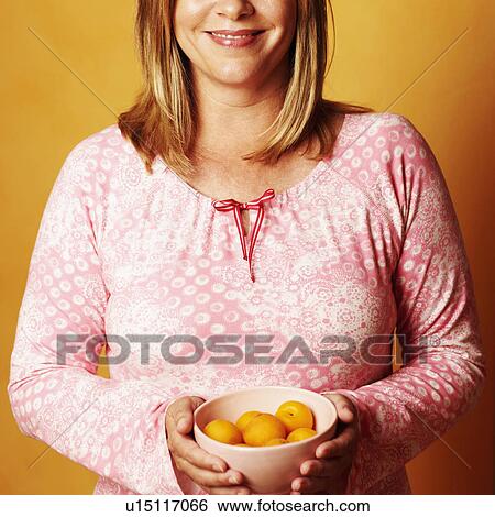 Portrait of a mature woman holding a bowl of peaches and smiling View Large Photo Image Stock Photograph - Portrait of a mature woman holding a bowl of peaches and smiling. Fotosearch