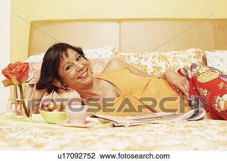 Portrait of a mature woman lying on the bed and smiling View Large Photo Image Stock Image - Portrait of a mature woman lying on the bed and smiling. Fotosearch