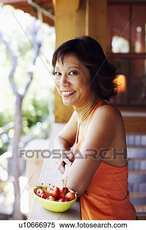 Portrait of a mature woman standing in a balcony and smiling View Large Photo Image Stock Photography - Portrait of a mature woman standing in a balcony and smiling. Fotosearch
