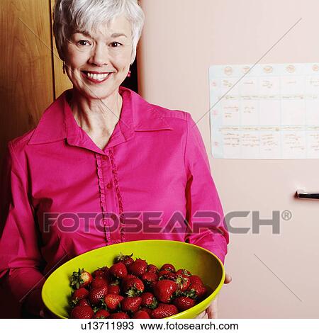 Portrait of a senior woman holding a fruit bowl of strawberries View Large Photo Image Stock Image - Portrait of a senior woman holding a fruit bowl of strawberries. Fotosearch