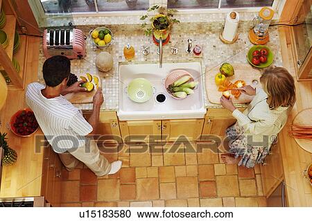 High angle view of a mature couple cutting vegetables in the kitchen View Large Photo Image Stock Image - High angle view of a mature couple cutting vegetables in the kitchen. Fotosearch