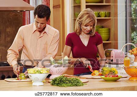 Mature couple cutting vegetables in the kitchen View Large Photo Image Stock Photo - Mature couple cutting vegetables in the kitchen. Fotosearch