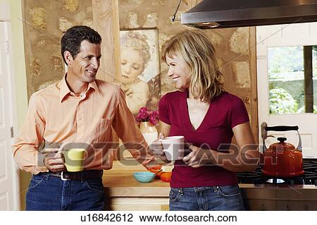 Mature couple smiling and holding cups View Large Photo Image Stock Image - Mature couple smiling and holding cups. Fotosearch