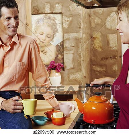 Mature couple smiling in the kitchen View Large Photo Image Stock Image - Mature couple smiling in the kitchen. Fotosearch