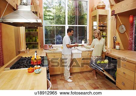 Mature woman and a mature man standing in the kitchen View Large Photo Image Stock Photography - Mature woman and a mature man standing in the kitchen. Fotosearch