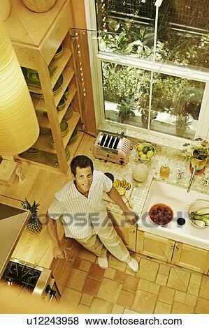 Portrait a mature man standing in the kitchen View Large Photo Image Stock Photo - Portrait a mature man standing in the kitchen. Fotosearch