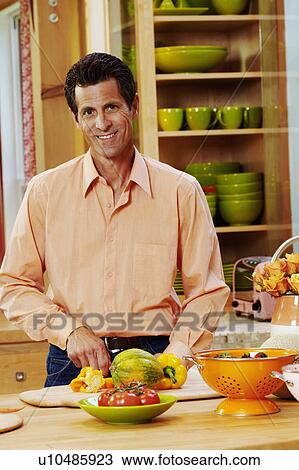 Portrait of a mature man cutting vegetables in a kitchen View Large Photo Image Stock Image - Portrait of a mature man cutting vegetables in a kitchen. Fotosearch
