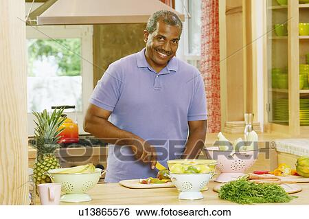 Portrait of a mature man cutting vegetables in a kitchen and smiling View Large Photo Image Stock Photograph - Portrait of a mature man cutting vegetables in a kitchen and smiling. Fotosearch