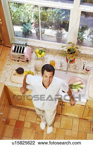 Portrait of a mature man standing in a kitchen View Large Photo Image Stock Image - Portrait of a mature man standing in a kitchen. Fotosearch