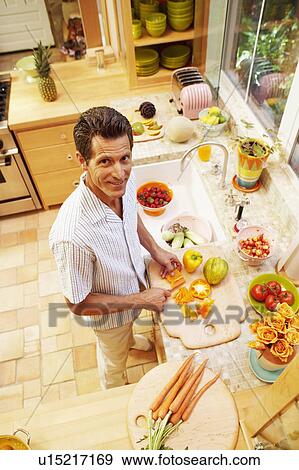 Portrait of a mature woman cutting yellow bell peppers in the kitchen View Large Photo Image Stock Photo - Portrait of a mature woman cutting yellow bell peppers in the kitchen. Fotosearch