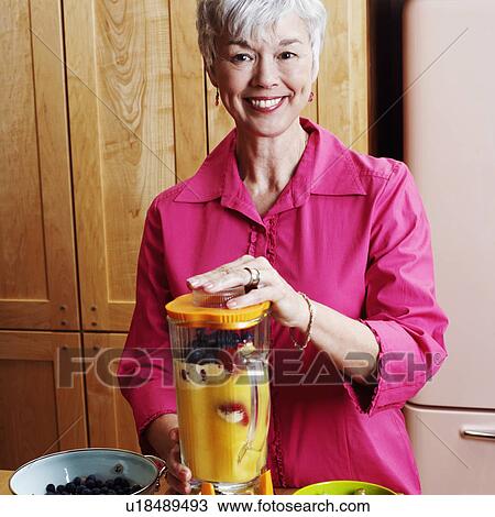 Portrait of a senior woman preparing mango shake in the kitchen View Large Photo Image Stock Image - Portrait of a senior woman preparing mango shake in the kitchen. Fotosearch