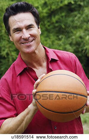 Picture - Close-up of a mature man holding a basketball. Fotosearch