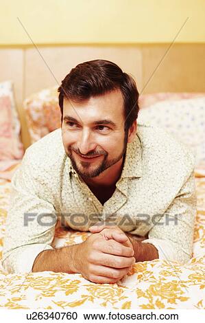 Close-up of a mature man lying on the bed and smiling View Large Photo Image Stock Image - Close-up of a mature man lying on the bed and smiling. Fotosearch