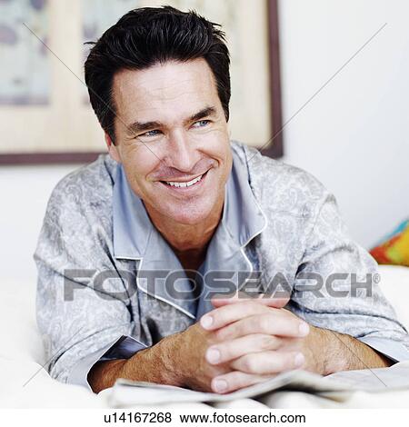 Close-up of a mature man lying on the bed and smiling View Large Photo Image Stock Photo - Close-up of a mature man lying on the bed and smiling. Fotosearch