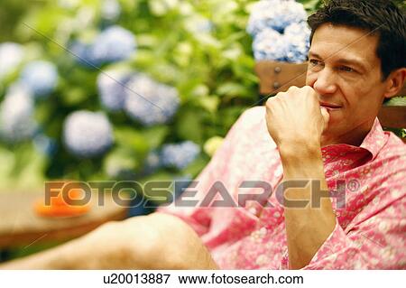 Stock Photo - Close-up of a mature man sitting on a chair and thinking. Fotosearch