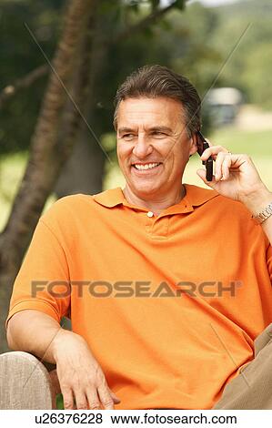 Stock Photo - Close-up of a mature man talking on a mobile phone and smiling. Fotosearch