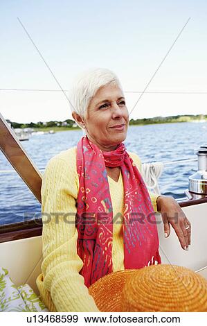 Close-up of a mature woman sitting in a boat and smirking View Large Photo Image Stock Photo - Close-up of a mature woman sitting in a boat and smirking. Fotosearch
